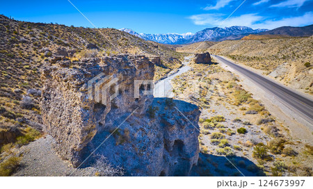 Aerial of Rugged Desert Rock Formations and Mt Charleston Snowcaps 124673997
