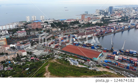 Cargo cranes loading shipping containers at vladivostok seaport, managing maritime trade operations for pacific regional commerce Cargo cranes loading shipping containers at vladivostok seaport, managing maritime trade operations for pacific regional commerce 124674182