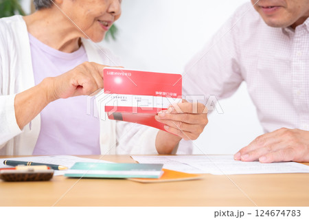通帳を見る親子 手元 通帳を見る親子 手元 124674783