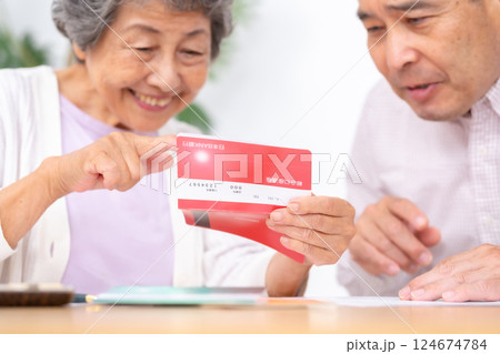 通帳を見る親子 手元 通帳を見る親子 手元 124674784