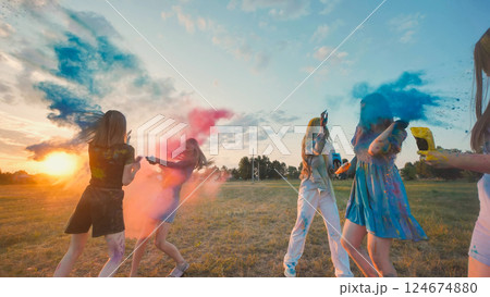 Cheerful school friends throwing colorful gulal powder, celebrating friendship and the end of school year at sunset Cheerful school friends throwing colorful gulal powder, celebrating friendship and the end of school year at sunset 124674880