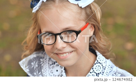 Portrait of a smiling 13 year old girl put on glasses. Face close up. 124674982