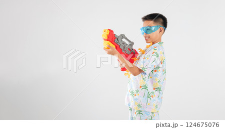 Songkran festival happiness as a smiling child boy plays with a water gun 124675076