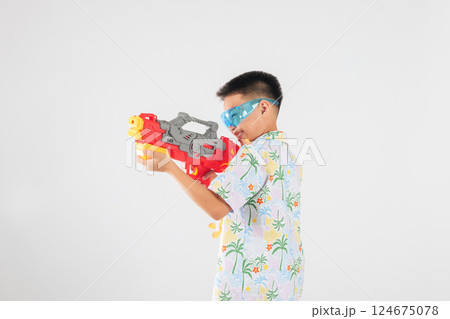 Songkran festival happiness as a smiling child boy plays with a water gun Songkran festival happiness as a smiling child boy plays with a water gun 124675078