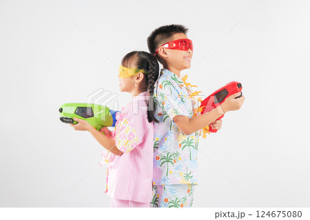 Songkran fun with a cheerful Thai boy and girl enjoying toy water pistols together 124675080