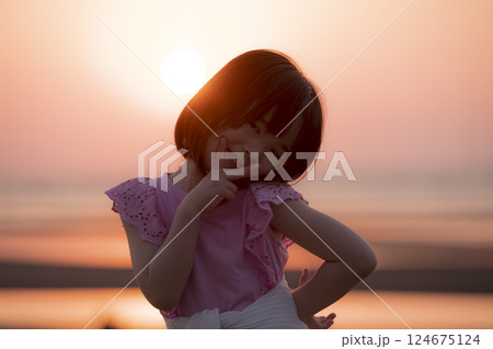 日没の砂浜でほほえむ少女 124675124