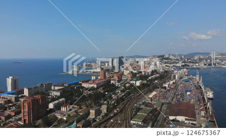 Aerial view of vladivostok, russia, showcasing the cityscape, cargo port, zolotoy rog bay, and russky bridge under a clear blue sky Aerial view of vladivostok, russia, showcasing the cityscape, cargo port, zolotoy rog bay, and russky bridge under a clear blue sky 124675367