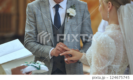 Wedding ring gliding onto finger, symbolizing eternal love and matrimonial bond between newlywed couple Wedding ring gliding onto finger, symbolizing eternal love and matrimonial bond between newlywed couple 124675745