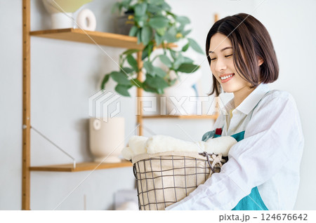 洗濯かごを抱えた若い女性 124676642