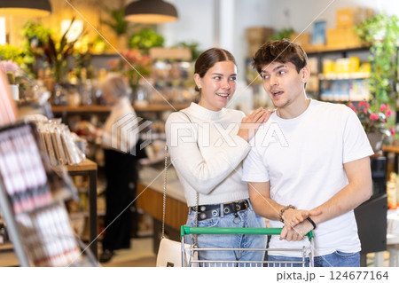 Couple man and woman with shopping cart choosing products 124677164
