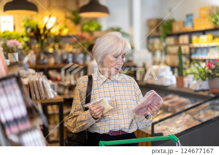 Elderly woman choosing cheese and bacon in grocery supermarket Elderly woman choosing cheese and bacon in grocery supermarket 124677167