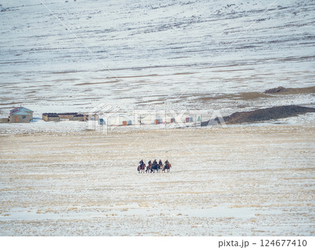 Mongolian horsemen, yurts and snow mountains. 124677410