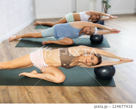 Young woman performing exercises with pilates ball in fitness studio 124677418