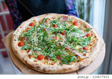 Homemade Ham Pizza slices (with rocket, fresh tomatoes, garlic and cheese) 124677933