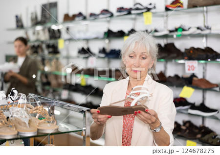 Senior woman choosing summer sandals in shoe store Senior woman choosing summer sandals in shoe store 124678275