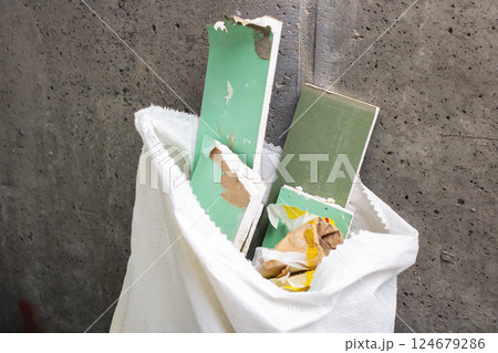 A white bag that is filled with various green and white pieces of paper A white bag that is filled with various green and white pieces of paper 124679286