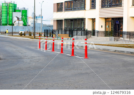 A row of red and white poles on the road enhances the scenery 124679316