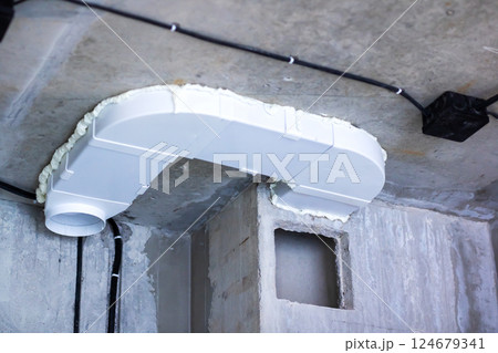 A white pipe is currently hanging from the ceiling inside a room 124679341