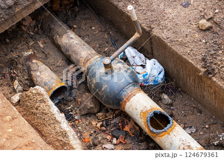 A pipe that has a hole in it is currently laying in the dirt A pipe that has a hole in it is currently laying in the dirt 124679361