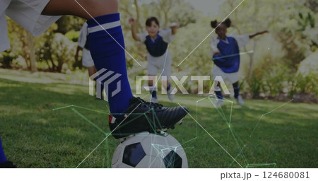 Playing soccer, children in blue uniforms with network connections image over them 124680081