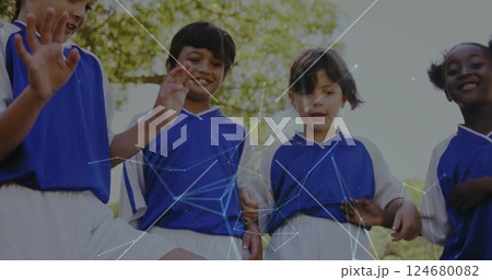 Playing soccer, children in blue uniforms with network connections image over them 124680082