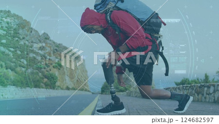 Kneeling hiker with prosthetic leg adjusting shoe, surrounded by data processing image 124682597