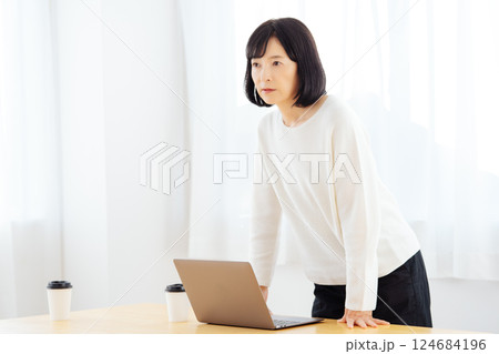 休日に急遽打合せをするミドルキャリアウーマン 124684196