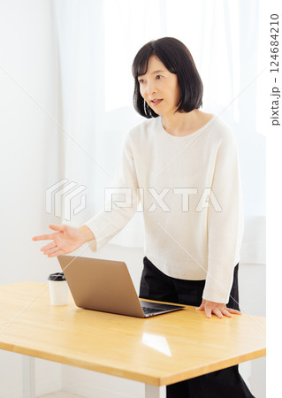 休日に急遽打合せをするミドルキャリアウーマン 124684210
