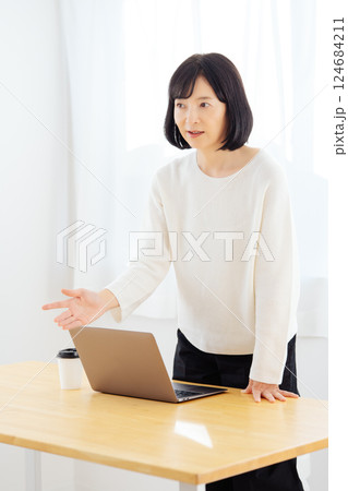 休日に急遽打合せをするミドルキャリアウーマン 124684211