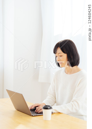 休日に急遽打合せをするミドルキャリアウーマン 124684245