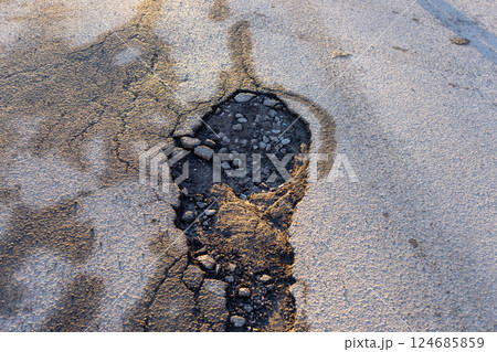 potholes in the road, holes in the asphalt on the roadway or highway. potholes in the road, holes in the asphalt on the roadway or highway. 124685859