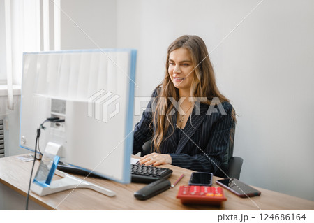 Young woman working on computer in a modern office during daylight hours 124686164