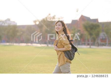 Traveler asian woman in her 30s stands bathed in the golden glow of sunset, embracing the freedom of exploration. on summer holiday weekend vacation trip in Bangkok, Thailand 124686615