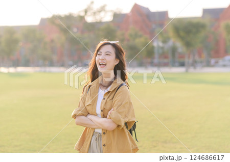Traveler asian woman in her 30s stands bathed in the golden glow of sunset, embracing the freedom of exploration. on summer holiday weekend vacation trip in Bangkok, Thailand 124686617