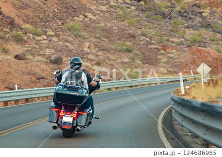 Biker couple riding chopper through mountain road 124686985