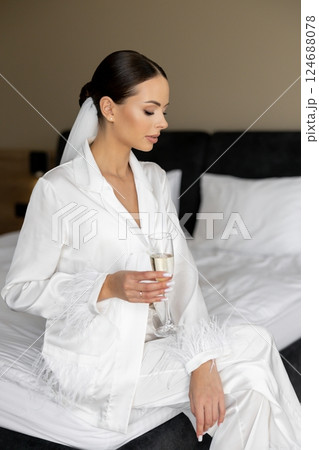 Bride enjoying champagne in hotel room before wedding ceremony 124688078