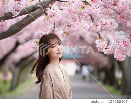 一般女性が満開の桜並木で記念写真 124688107