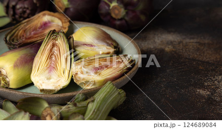 Plate full of cut purple raw artichokes closeup. Fresh italian vegetables from farmers market Plate full of cut purple raw artichokes closeup. Fresh italian vegetables from farmers market 124689084