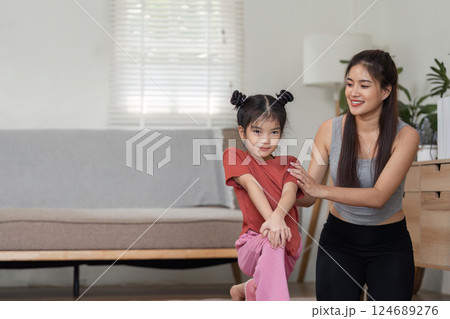 Fitness and Guidance. A mother assisting her daughter in yoga practice. 124689276