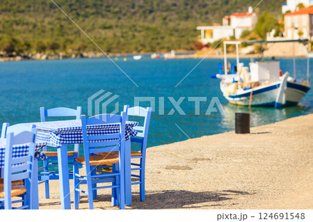 Open cafe outdoor restaurant in Greece on sea shore 124691548