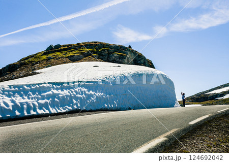 Tourist taking photo from high snow wall at road, Norway 124692042