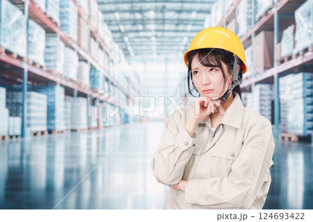 倉庫の中で頭を抱える女性の従業員 倉庫の中で頭を抱える女性の従業員 124693422