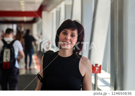 A woman in a bright, long corridor of the Dubai Metro 124693636