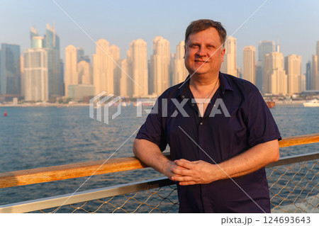 Blond man on Dubai promenade in the rays of the setting sun 124693643