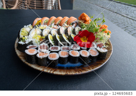 Colorful Japanese Sushi Platter with Variety of Rolls and Edible Flowers Colorful Japanese Sushi Platter with Variety of Rolls and Edible Flowers 124693683