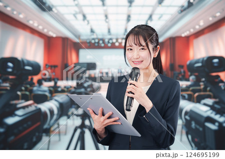 記者会見場からレポートをする女性のアナウンサー 記者会見場からレポートをする女性のアナウンサー 124695199