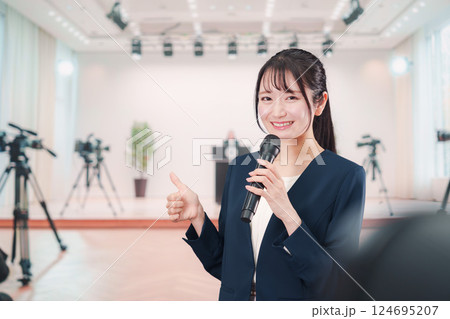記者会見場からレポートをする女性のアナウンサー 124695207