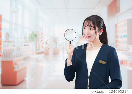 笑顔でルーペを持つ美容部員の女性 124695234