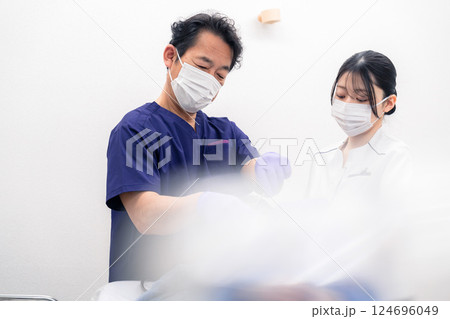 歯科治療をする歯科医師と歯科助手 124696049