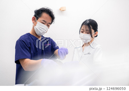 歯科治療をする歯科医師と歯科助手 124696050